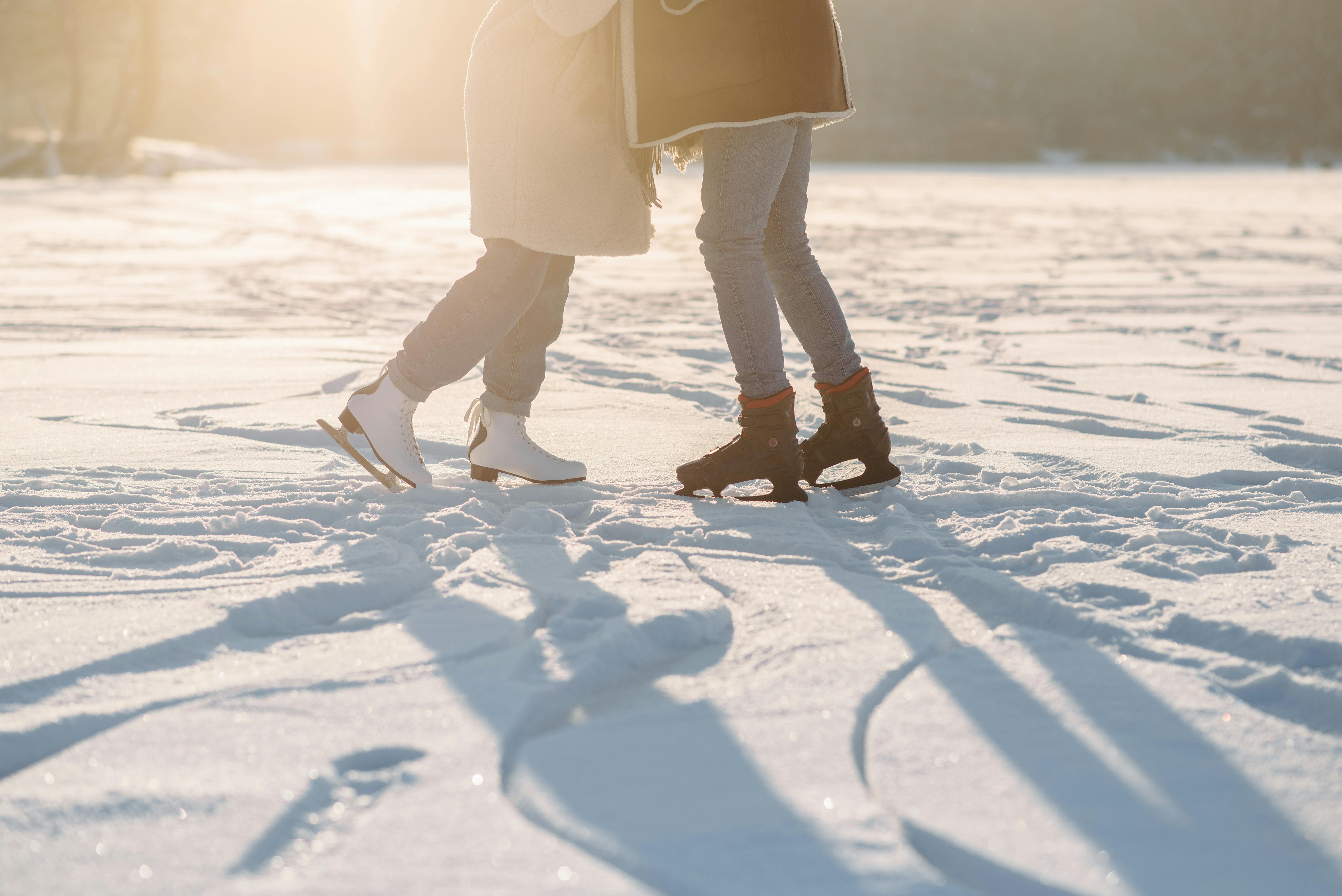 Two people hugging while on ice skates.