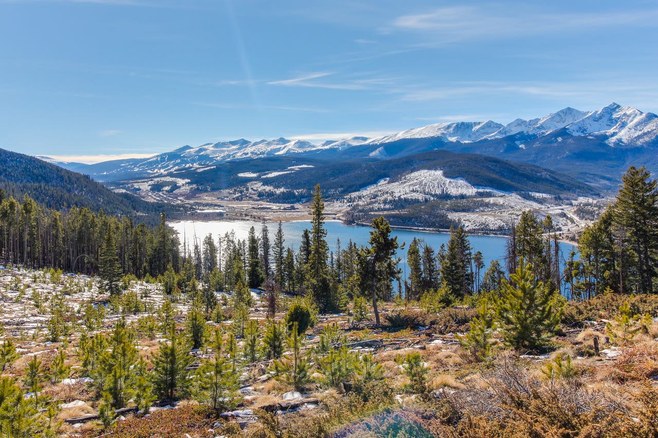 Snowcapped mountains, river, and pines