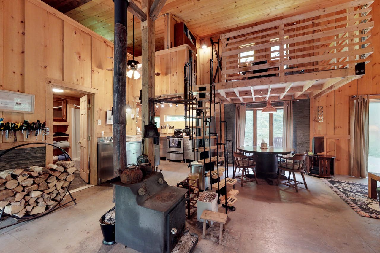 Interior of West Wardsboro, VT vacation rental with spiral staircase, wood-burning stove, kitchen and dining area