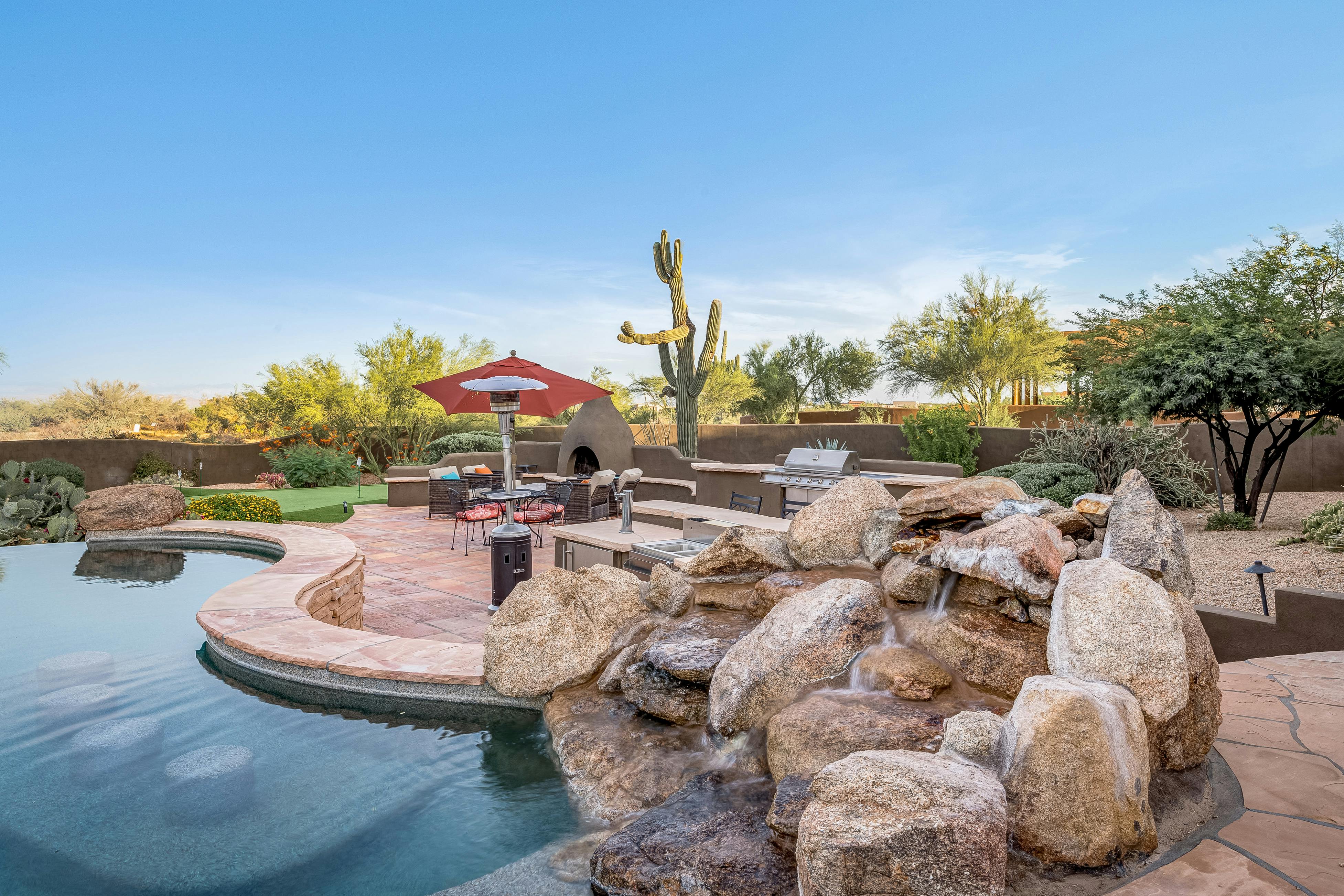 backyard of scottsdale, az vacation home with infinity pool and desert landscaping