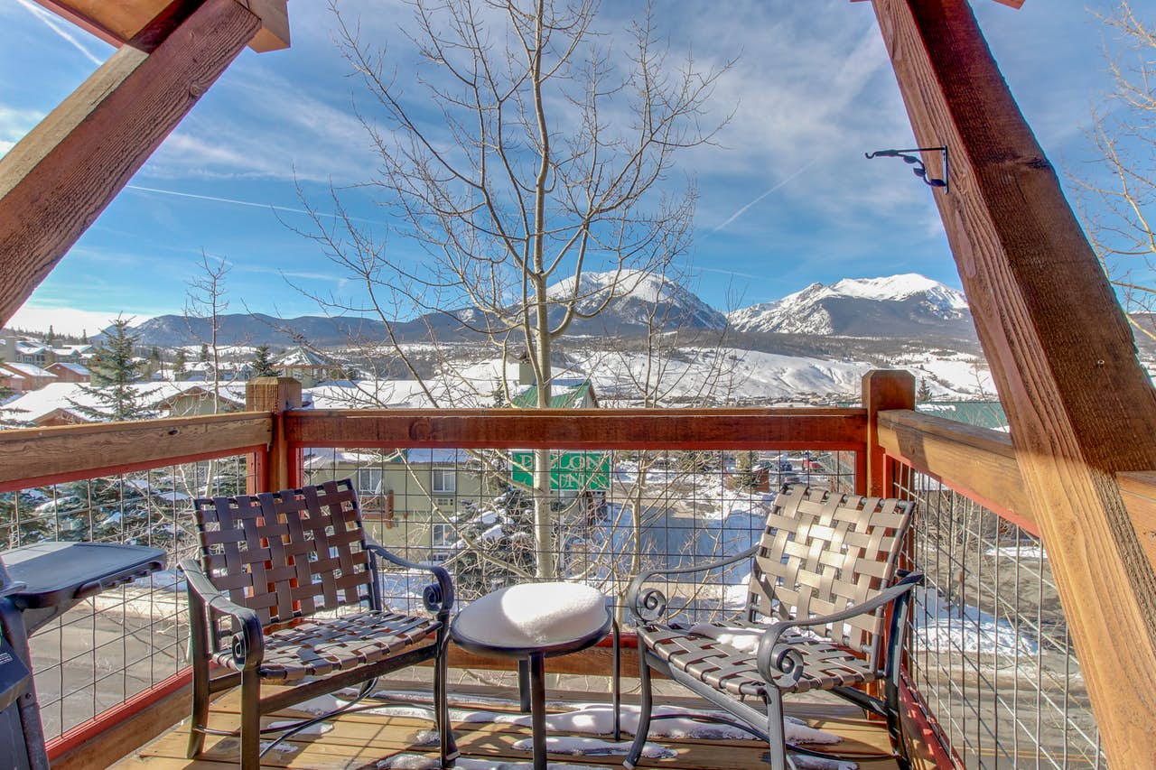 Two chairs on the deck of a Dillon, CO vacation home, with views of the mountains in the background