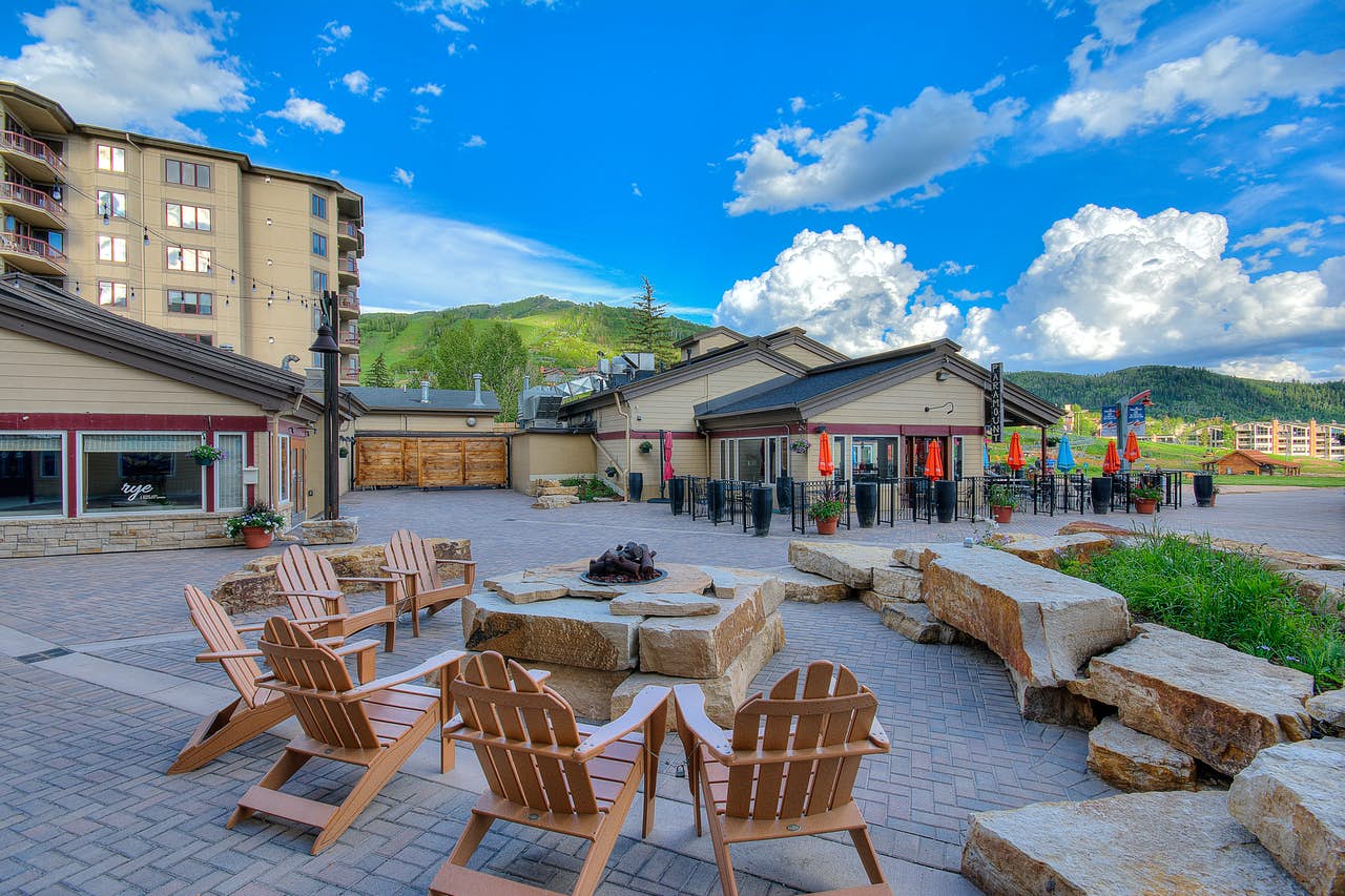 Outdoor chairs surrounding an outdoor stone fireplace at Torian Plum in Steamboat Springs, CO