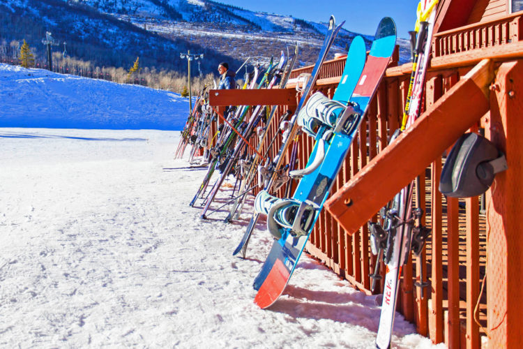 Snowboards and skies leaning against racks at the lodge in Park City, UT