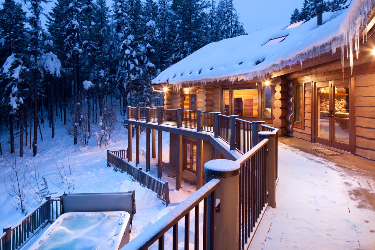 outside a Whitefish cabin in the wintertime, with the warm hot tub in the snow