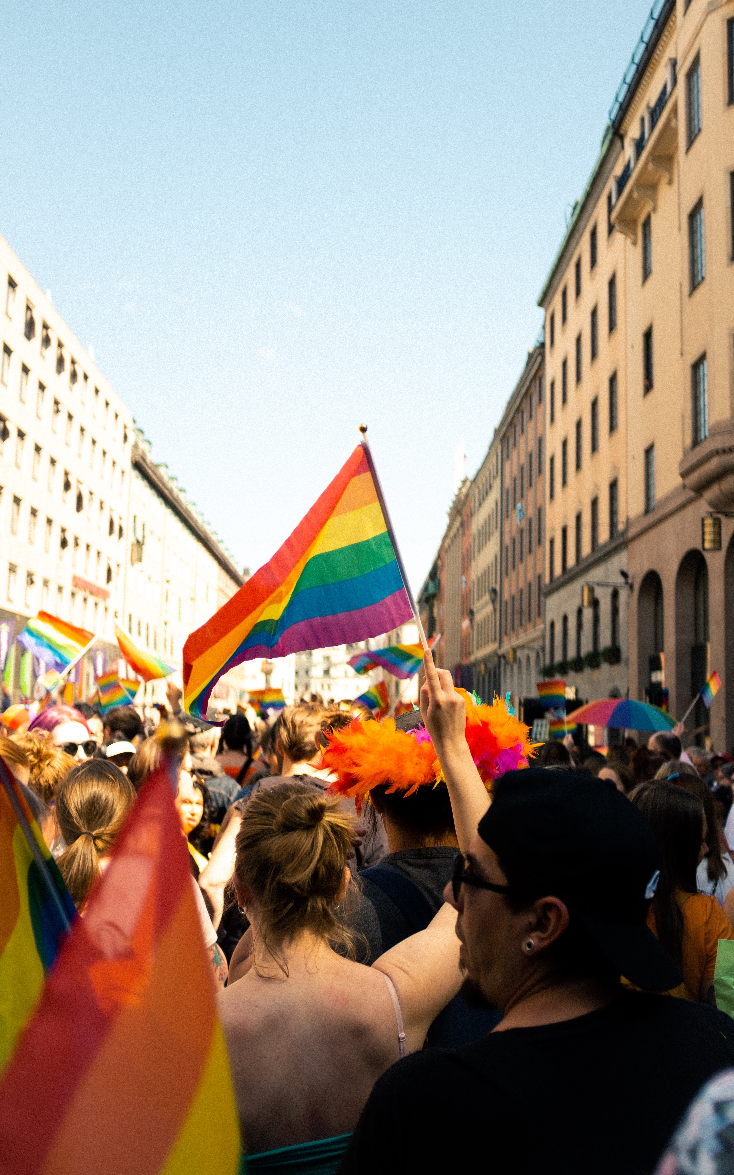 Woman holding a rainbow flag during a Pride event.